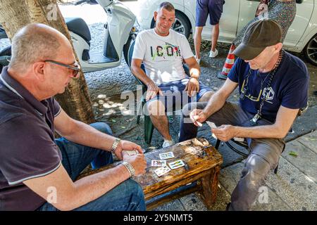 Messina Sizilien Italien, Via Loggia dei Mercanti, außen, Seniorenmännchen Freunde, Bewohner Nachbarn, Spielkarten Bürgersteig Kartenspiel, Spanisch-Anzug Stockfoto