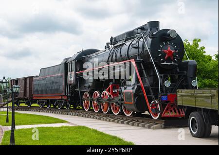 Nazran, Inguschetien, RUSSLAND - 12. MAI 2024: Gedenkstätte für Erinnerung und Ruhm. Große Personendampflokomotive auf der Hauptstrecke. Klassischer Eisenbahnverkehr. Transpo Stockfoto