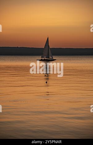 Segelboot bei Sonnenuntergang mit Abendlicht auf dem Ammersee bei Herrsching, Bayern, Deutschland, Europa Stockfoto