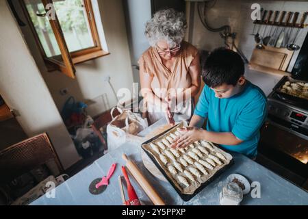 Großmutter und Enkel backen Gebäck in gemütlicher Küche Stockfoto