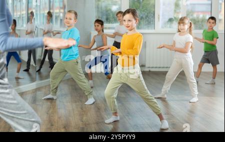 Kinder, die modernen Tanz trainieren, bewegen sich gemeinsam im Studio unter der Leitung des Lehrers Stockfoto