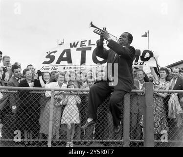 Jazz-Legende Louis „Satchmo“ Armstrong spielt Trompete für Fans bei der Ankunft in Mascot, Sydney, 27. Oktober 1954 Stockfoto