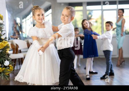 Jugendliche in eleganten Outfits üben im Weihnachtsstudio Partnertanz Stockfoto