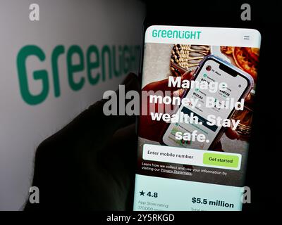 In dieser Abbildung befindet sich ein Mobiltelefon mit der Webseite des US-amerikanischen Fintech-Unternehmens Greenlight Financial Technology Inc. Mit Logo. Stockfoto