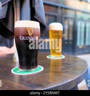 Ein Glas Guinness Stout Bier mit cremigem Schaumkopf im Guinness-Lagerhaus am St. James Gate in Dublin, Irland; Brian Boru Harfe Logo. Stockfoto