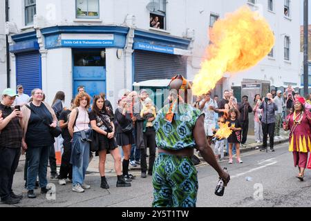 Eine Feuerpause der Gahu Dramatic Arts Gruppe begeistert die Menge während der Hackney Carnival Parade 2024. Stockfoto