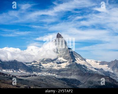 Blick auf das große Matterhorn in den Schweizer Alpen. Fantastischer Blick auf den pyramidalen Gipfel des Matterhorns mit weißer geschwollener Wolke auf blauem Himmel Hintergrund, Tourist de Stockfoto