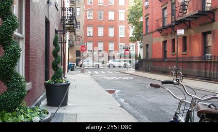 New York City Gebäudearchitektur. Städtisches Wohnhaus außen. Immobilien in den USA. Allgemeine rote Ziegelfassade. Greenwich Village Gay Street. Fluchtleiter. Halt, Einbahnschild. Stockfoto