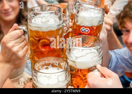 Wiesnbesucher stoßen im Hacker-Festzelt mit Ihrer Maß Bier an, Oktoberfest, München, September 2024 Deutschland, München, September 2024, Wiesnbesucher stoßen im Hackerzelt mit Ihrer Maß Bier an, Biertrinker, Maßkrüge, Hacker Festzelt Werbespruch der Himmel der Bayern, Bierpreis im Festzelt 15,10 Euro, Oktoberfest, typisch bayerisch, Volksfest, Bayern, *** Wiesn-Besucher stoßen mit ihrem Maß Bier im Hacker-Zelt an, Oktoberfest, München, September 2024 Deutschland, München, September 2024 stoßen Wiesn-Besucher mit ihrem Maß Beer im Hacker-Zelt, Biertrinker, Maß Tassen, Hacker-Zeltwerbung an Stockfoto