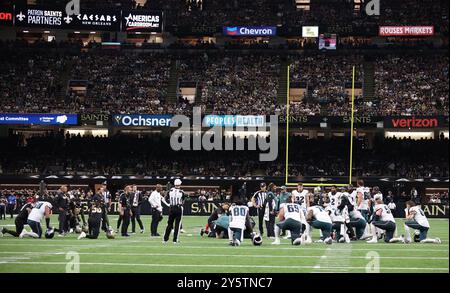 New Orleans, Usa. September 2024. Spieler beider Mannschaften knien ein Knie, während der Philadelphia Eagles Wide Receiver DeVonta Smith (6) während eines National Football League-Wettbewerbs im Caesars Superdome am Sonntag, den 22. September 2024 in New Orleans, Louisiana, wegen einer möglichen Gehirnerschütterung versorgt wird. (Foto: Peter G. Forest/SIPA USA) Credit: SIPA USA/Alamy Live News Stockfoto