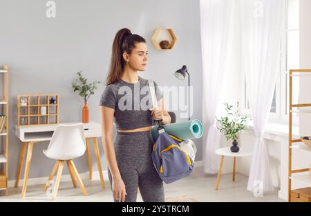 Porträt einer Athletin mit Sporttasche zu Hause Stockfoto
