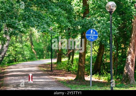 Eingang zum Stadtpark. Schild für Fuß- und Fahrradwege. Natürliche grüne Erholung. Stockfoto