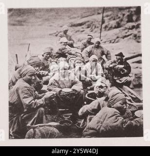 Von Hankou zur Wushan-Schlucht, Oberer Yangtse. Vintage-Foto der chinesischen Bootsbesatzung beim Frühstück. Von J. Thomson, F. R. G. S. Illustrations of Qing China, 1875 '... die Trommel vor diesem Foto ist ein Instrument, das über dem Brüllen des schnellen und schreienden der Tracker zu hören ist, und seine Töne sollen die Männer zu größerer Anstrengung nerven. In diesem Fall krochen die fünfzig Tracker, jeder mit seiner Bambusschlaufe über die Schultern geschlungen und an der Schleppleine befestigt, Zoll für Zoll vorwärts, Hände und Füße fest in den Felsen, auf dem Ufer, bis sie in Länge sind Stockfoto