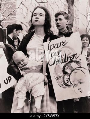 Die Little Denise Davidson, 5 Monate alt, schläft friedlich, während ihre Mutter, Mrs. Donald Davidson aus 278 Clinton St., Bklyn, mit Ban-the-Bombe-Gruppe vor den Vereinten Nationen marschiert, um gegen die Wiederaufnahme der A-Bombe-Tests durch die Vereinigten Staaten zu protestieren. USA. 1962 von D. DeMarsico, Fotograf Stockfoto