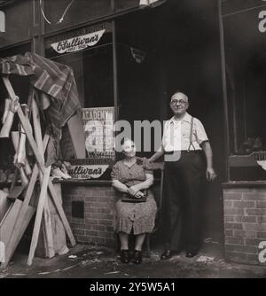 Amerika der 1940er Jahre Schuhmacher und seine Frau in der italienischen Sektion an der Mott Street. Waren Bilder zu Ehren des Festes von San Rocco rechts. New York. August 1942 von M. Collins, Fotograf Stockfoto