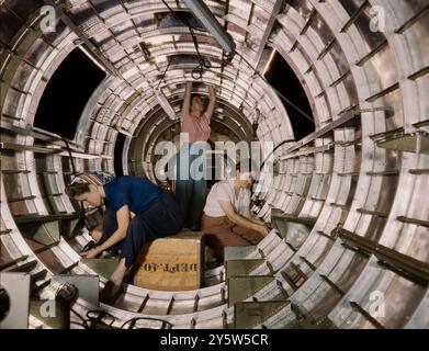 Amerika der 1940er Jahre Vintage-Foto von Arbeiterinnen installieren Befestigungen und Baugruppen an einem Heckrumpfabschnitt eines B-17F Bombers bei der Douglas Aircraft Company, Long Beach, Kalifornien Die B-17F ist ein späteres Modell der B-17, das sich im Südpazifik, über Deutschland und anderswo auszeichnete. Es handelt sich um einen schweren Bomber mit großer Reichweite, mit einer Besatzung von sieben bis neun Mann und einer ausreichenden Bewaffnung, um sich bei Tageslichtmissionen zu verteidigen. USA. Oktober 1942 von A. T. Palmer, Fotograf Stockfoto