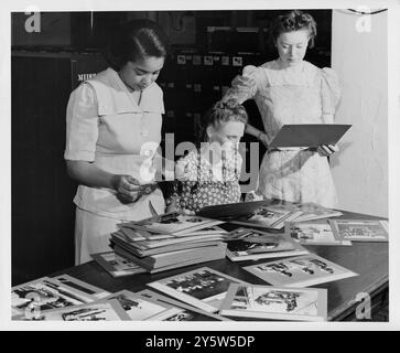 Fredrycka Weaver, Rachel Paczkowzki und Katryna Lee Kritzer untersuchten Fotos im Büro der Auslandsabteilung des U.S. Office of war Information in Washington. USA. 1945 Stockfoto