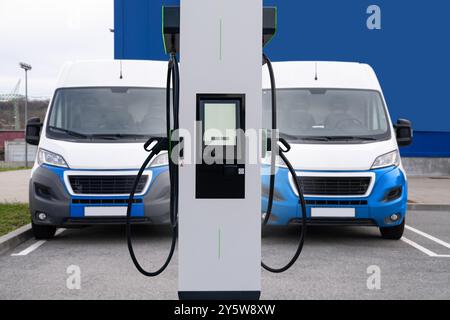 Elektrische Lieferwagen mit Ladestation für Elektrofahrzeuge. Stockfoto