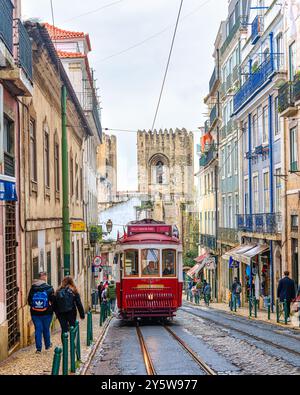 Lissabon, Portugal - 19. September 2024: Alte Straßenbahn oder Straßenbahn fahren in der Altstadt. Die Leute sind unterwegs an diesem berühmten Ort. Stockfoto