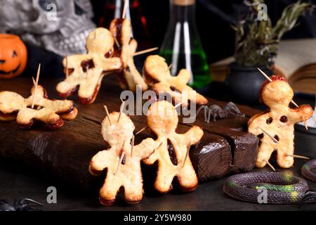 Voodoo-Kekse aus Blätterteig mit Marmelade und mit Holzspießen durchstochen. Idee für die Halloween-Party Stockfoto