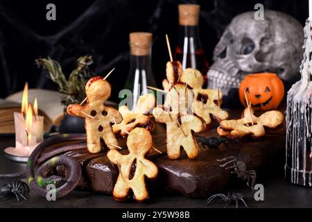 Voodoo-Kekse aus Blätterteig mit Marmelade und mit Holzspießen durchstochen. Idee für die Halloween-Party Stockfoto