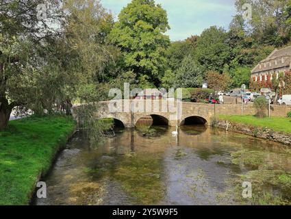 Brücke über den Fluss Coln bei Bibiury Gloucestershire mit einem Mute Swan auf dem Wasser Stockfoto