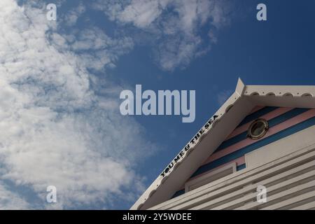 Eine positive Botschaft, die am Dachrand einer bunten Strandhütte vor einem blauen Himmel mit schroffen Wolken geschrieben wurde Stockfoto