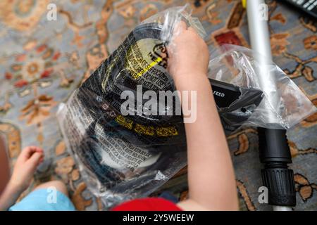 Paris, Frankreich - 25. Juni 2024: Ein Blick von oben auf eine Person, die Gartengeräte von Karcher auspackt, in einem Wohnzimmer Stockfoto