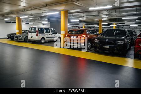 Basel, Schweiz - 8. September 2024: Auf einer großen Tiefgarage in Basel werden mehrere Autos geparkt, während ein elektrischer BMW iX1 aus dem Werk verlässt Stockfoto