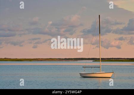 Ein einsames Segelboot liegt vor Anker in einem abgeschiedenen Hafen. Stockfoto