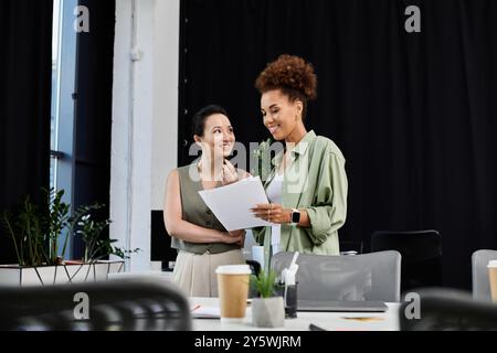 In einem modernen Büro führen zwei professionelle Frauen eine aufschlussreiche Diskussion und tauschen Ideen aus. Stockfoto
