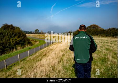 Nieby, Deutschland. September 2024. Ein Mitarbeiter des Schleswig-holsteinischen Landesamtes für Küstenschutz, Nationalpark und Meeresschutz geht bei einer Deichkontrolle über den Deich in Nieby. Quelle: Axel Heimken/dpa/Alamy Live News Stockfoto