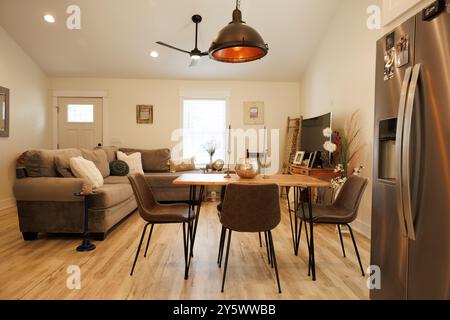 Moderne Küche und Essbereich mit Holzfußboden, Esstisch für vier Personen, Kühlschrank aus Edelstahl und gemütlichem Sofa, Florida, USA Stockfoto