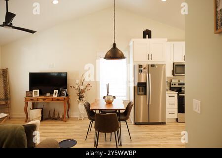 Modernes, gemütliches Wohnzimmer mit Essbereich mit eleganten Möbeln, Deckenventilator, Pendelbeleuchtung und Flachbild-TV, Florida, USA Stockfoto