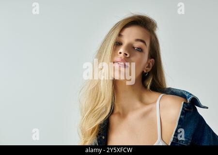 Eine atemberaubende junge Frau zeigt ihre natürliche Schönheit und trägt eine stilvolle Jeansjacke. Stockfoto