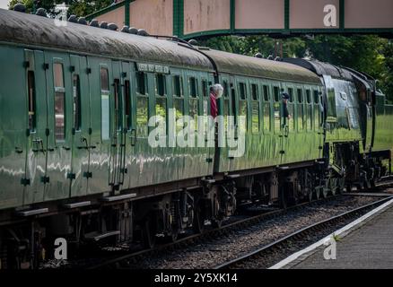 Ein Foto eines Zuges, der auf die Abfahrt vom Bahnhof Ropley wartet, Heimstadion der Watercress-Linie, Hampshire, England. Stockfoto