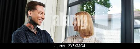 Zwei Kollegen teilen sich einen unbeschwerten Moment und fördern die Teamarbeit in ihrem stilvollen Arbeitsbereich. Stockfoto