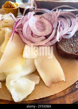 Roh gehackter Schweineschinken mit Fleisch, einem Kopf mit Knoblauch und Roggenbrot auf einem hölzernen Hintergrund für den Kopierraum. Ein großer Teil von frischem Fett. Ukrainischer Schmalz, tra Stockfoto