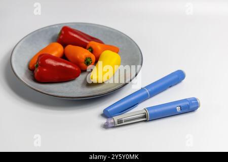 Ozempic Insulininjektionsstift für Diabetiker und Gewichtsverlust auf Platte mit Gemüse. Hochwertige Fotos Stockfoto