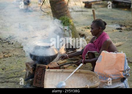 Eine Frau, die draußen Reis kocht. Das tägliche Leben in Bishnubati, einem Dorf in Santal in Sattore, Birbhum, Westbengalen, Indien. Stockfoto
