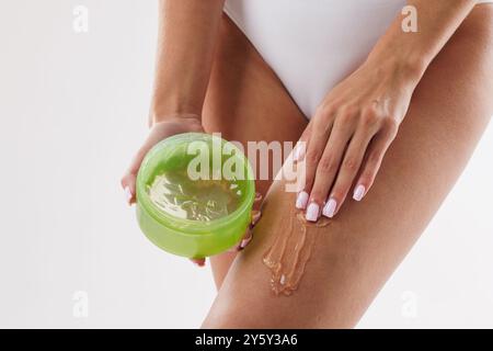 Frau, die Aloe Vera Extrakt auf Beine aufträgt Nahaufnahme, Konzept Hautpflege, Körper feuchtigkeitsspendend, schöne Beine Stockfoto