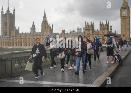 London, Großbritannien. 23. September 2024 Fußgänger auf der Westminster-Brücke, die bei Regenschauer mit Regenschirmen beschossen werden. Das Met-Büro hat eine gelbe Wetterwarnung in ganz Großbritannien veröffentlicht, wobei ein monatlicher Regen in 24 Stunden Überschwemmungen und Reiseunterbrechungen von Amer Ghazzal/Alamy Live News verursachte Stockfoto