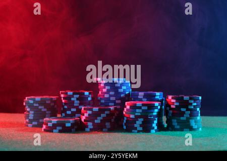 Pokerspiel. Casino Chips auf grünem Tisch in Neonlichtern Stockfoto