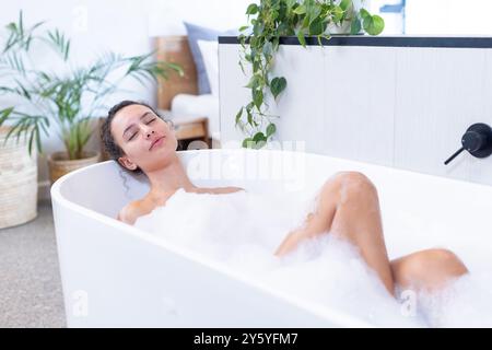 Entspannen in der Badewanne, Frau genießt Sprudelbad in Spa-Umgebung Stockfoto