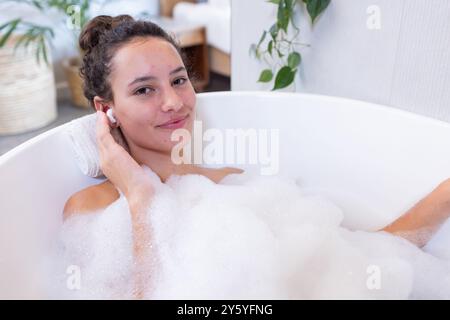 Entspannen Sie in der Badewanne mit Schaum, Frau genießt Spa-Behandlung zu Hause Stockfoto
