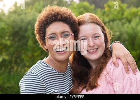 Umarmen und lächeln, Freundinnen genießen die gemeinsame Zeit im Freien in der Natur Stockfoto