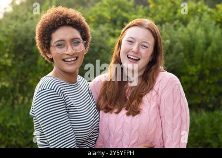 Zusammen im Freien stehen, lächelnde Freundinnen genießen Zeit und Bindung Stockfoto