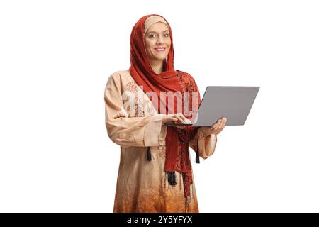 Junge Frau, die einen Hijab trägt und einen Laptop auf weißem Hintergrund isoliert hält Stockfoto