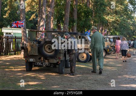 Holt, Norfolk, Großbritannien – 21. SEPTEMBER 2024: Männer in Infanterie-Uniformen der 1940er Jahre neben dem britischen Willys Jeep-Militärwagen Stockfoto
