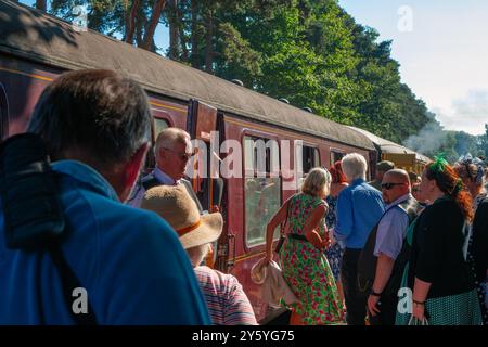 Holt, Norfolk, Vereinigtes Königreich - 21. SEPTEMBER 2024: Menschen in Vintage-Kleidung der 1940er Jahre warten am Bahnsteig vor dem Heritage Dampfzug Stockfoto